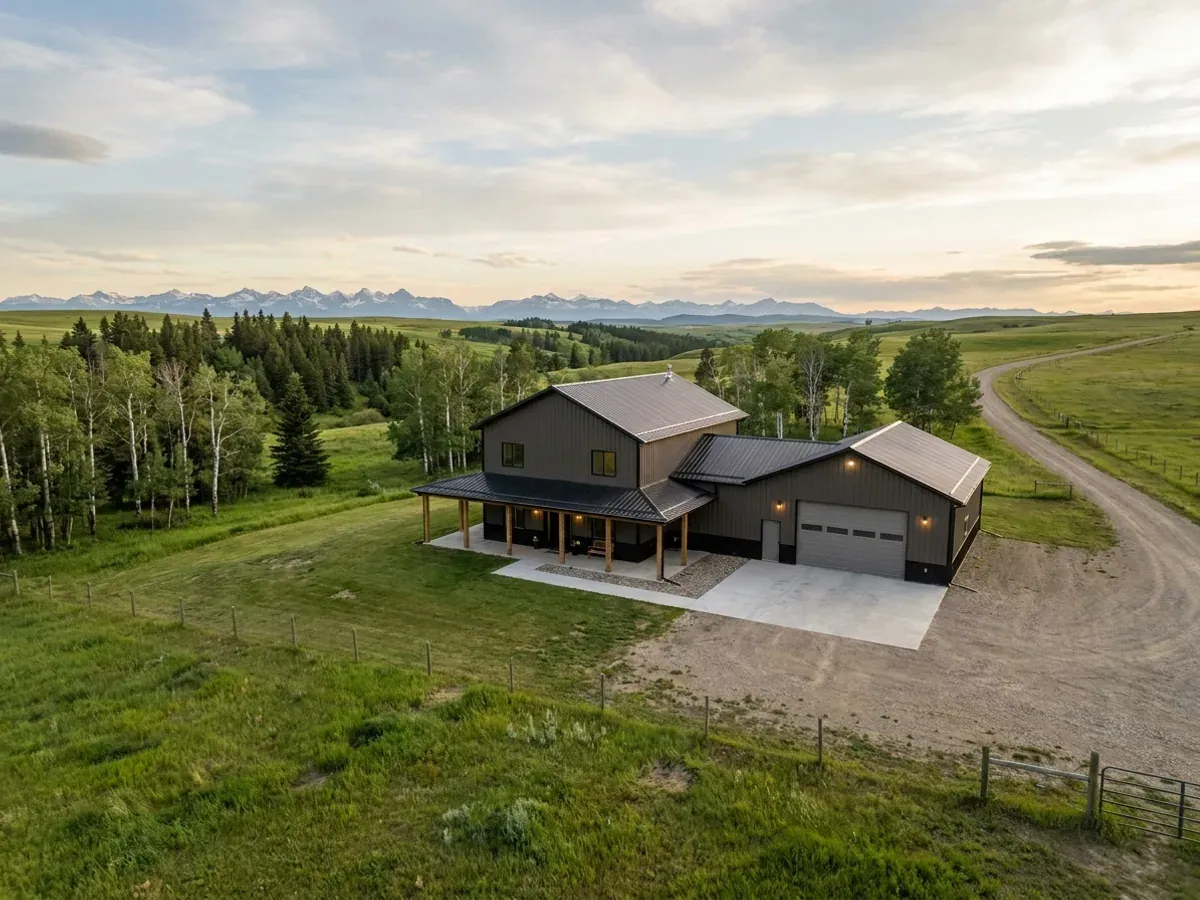 A completed barndominium home viewed from the front corner, with finished landscaping, a covered entry porch and an attached shop bay.